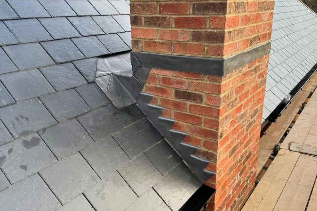 New lead flashing dressed into a roof abutment